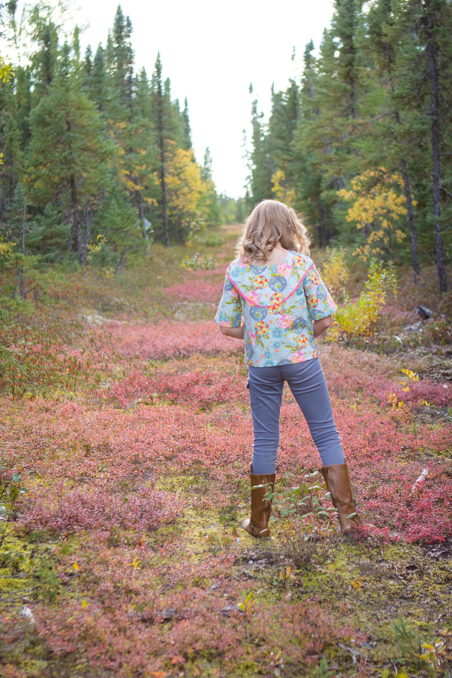 Raven woven top with split hem detail and ribbon details instead of ruffle along the dropped shoulder yoke detail. Mid length sleeves.
