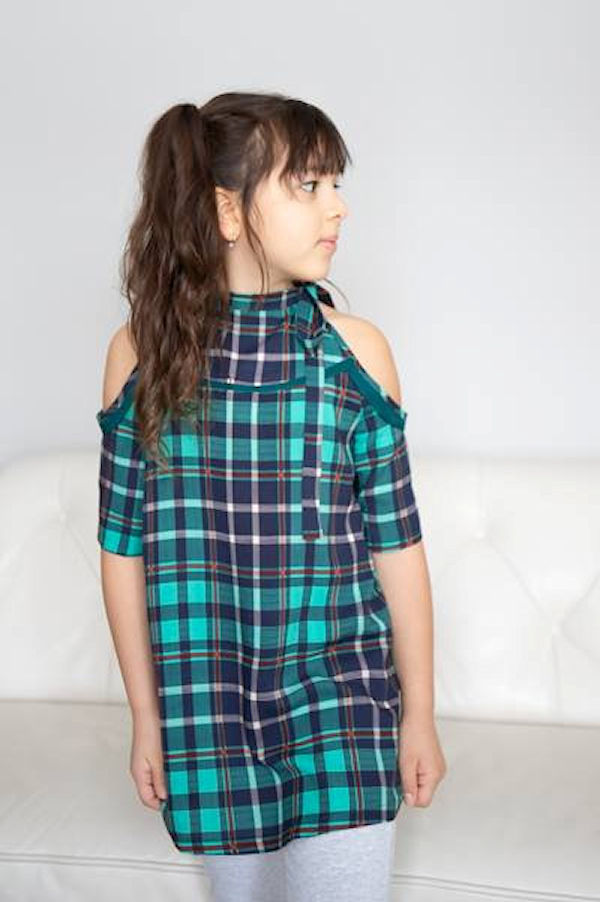 The cold shoulder Lynx dress with added detail along yoke and shoulder opening. Mid length sleeves. High neckline with tie on one side.