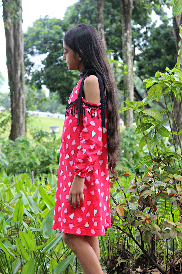 The cold shoulder Lynx dress with fringe embellishment along the yoke and long sleeves with elastic wrist.