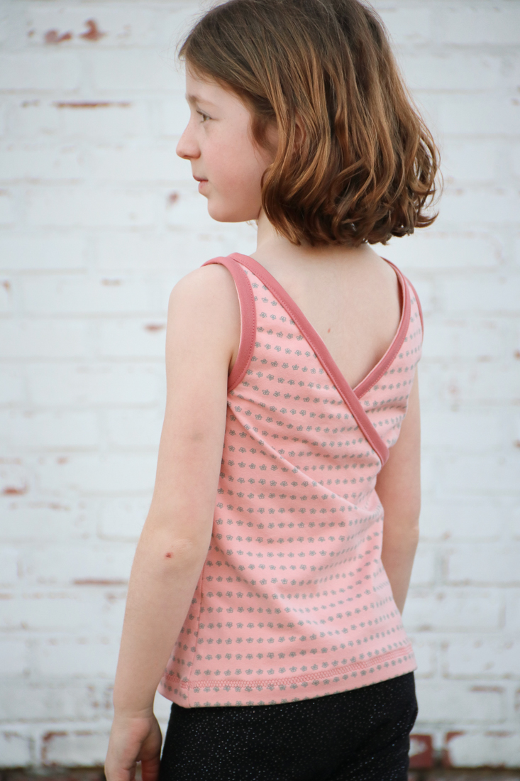 Dandelion Peplum tank with criss cross back and visible facings for a pop of colour and detail.