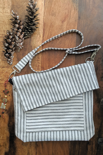 The Balsam Bag fundraising bag for A21. Envelope corners, fold over top, cross body strap and front pocket.