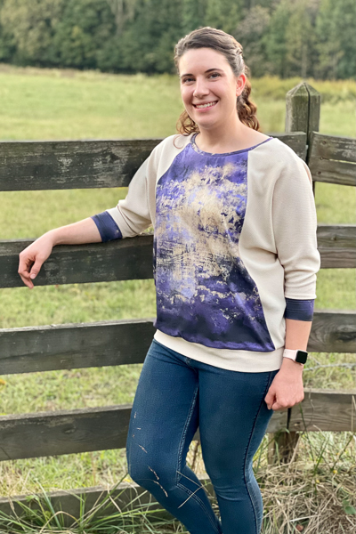 A hip length raglan sweater with batwing sleeves and round neckline.